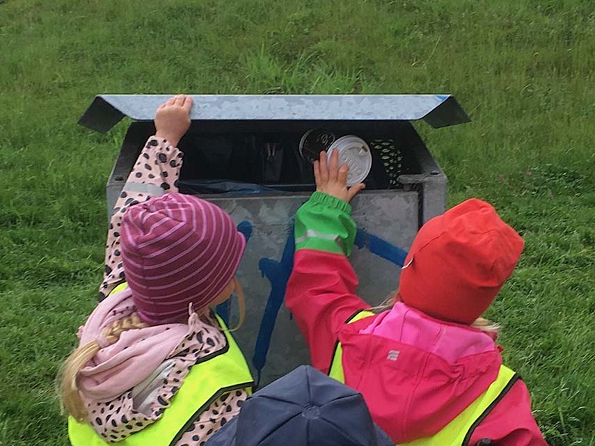 Barn slänger skräp i papperskorg. Foto: Anna Sundblad