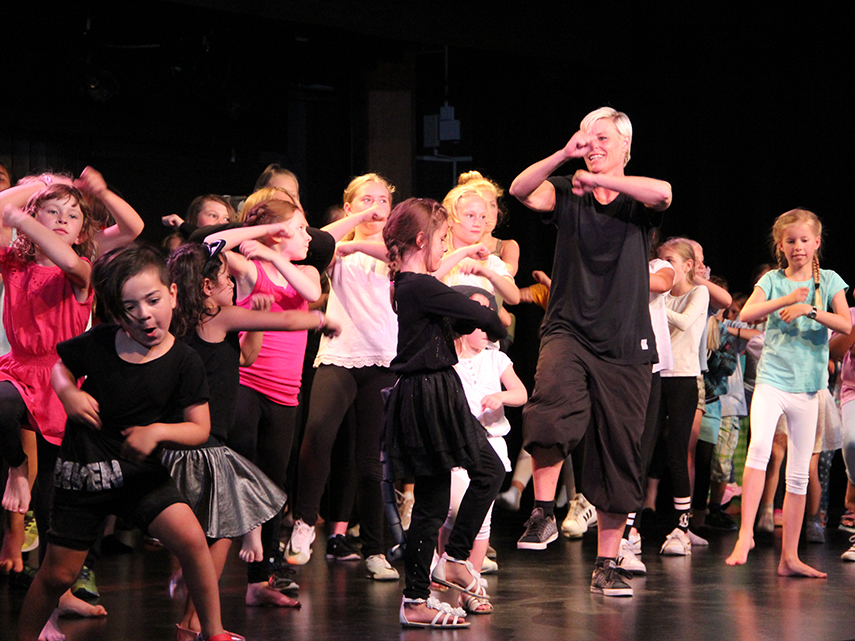 Massor av barn och lärare dansar huller om buller på en scen. Foto: Johannes Nordgren 2018