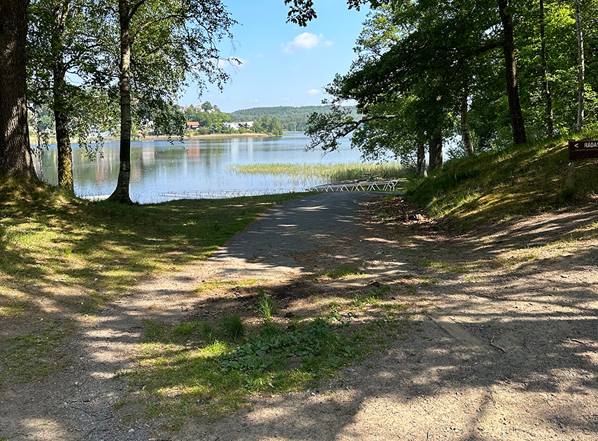 En väg ner till en sjö, med träd runt om.