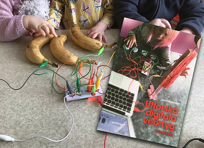 bok på ett bord i klassrum med elev som utför experiment