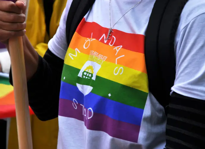 Prideflagga med Mölndals stadslogotyp på en tshirt