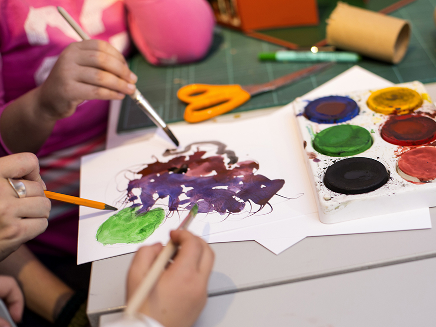 Barnhänder som målar med vattenfärg. Foto: Maja Kristin Nylander.