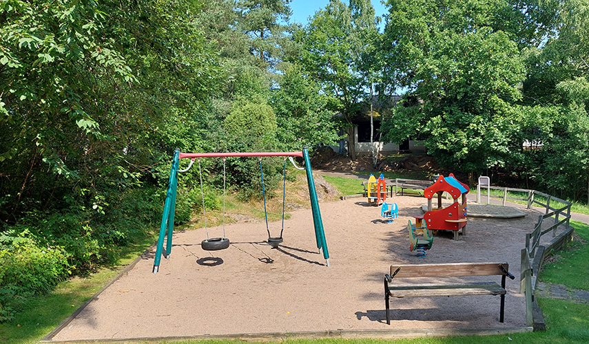 En lekplats vid Bräckavägen i Lindome med gungor, sandlek och lekhus.