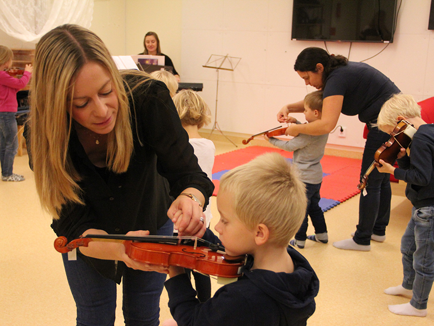 Pedagoger visar hur barn i förskolan ska hålla en fiol.