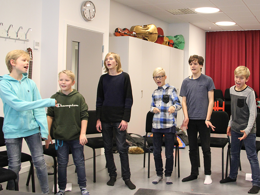 Några killar står i en undervisningssal och sjunger. Foto: Maria Karlsson 2018