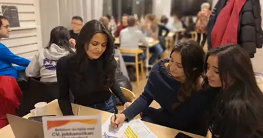 Tre kvinnor sitter vid ett bord på Mötesplats Möllan