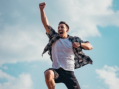 En man sträcker ut armen medan han hoppar i luften.