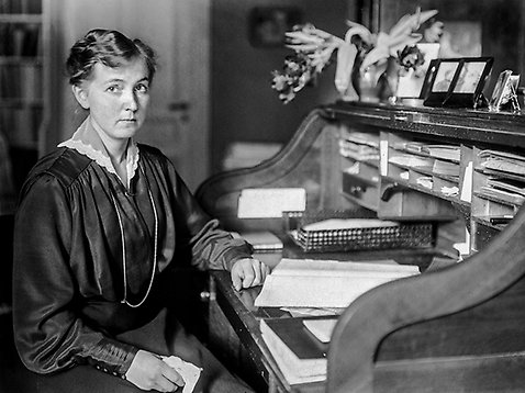 Eva Andén , Sveriges första kvinnliga advokat, sitter vid sitt skrivbord. Bild från 1920